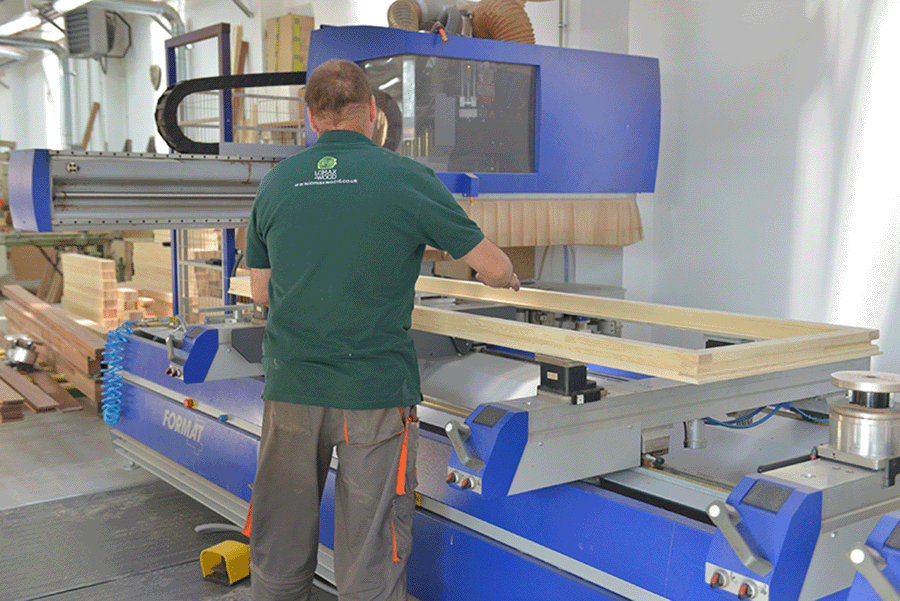 lomax + wood staff making a timber door frame in the factory