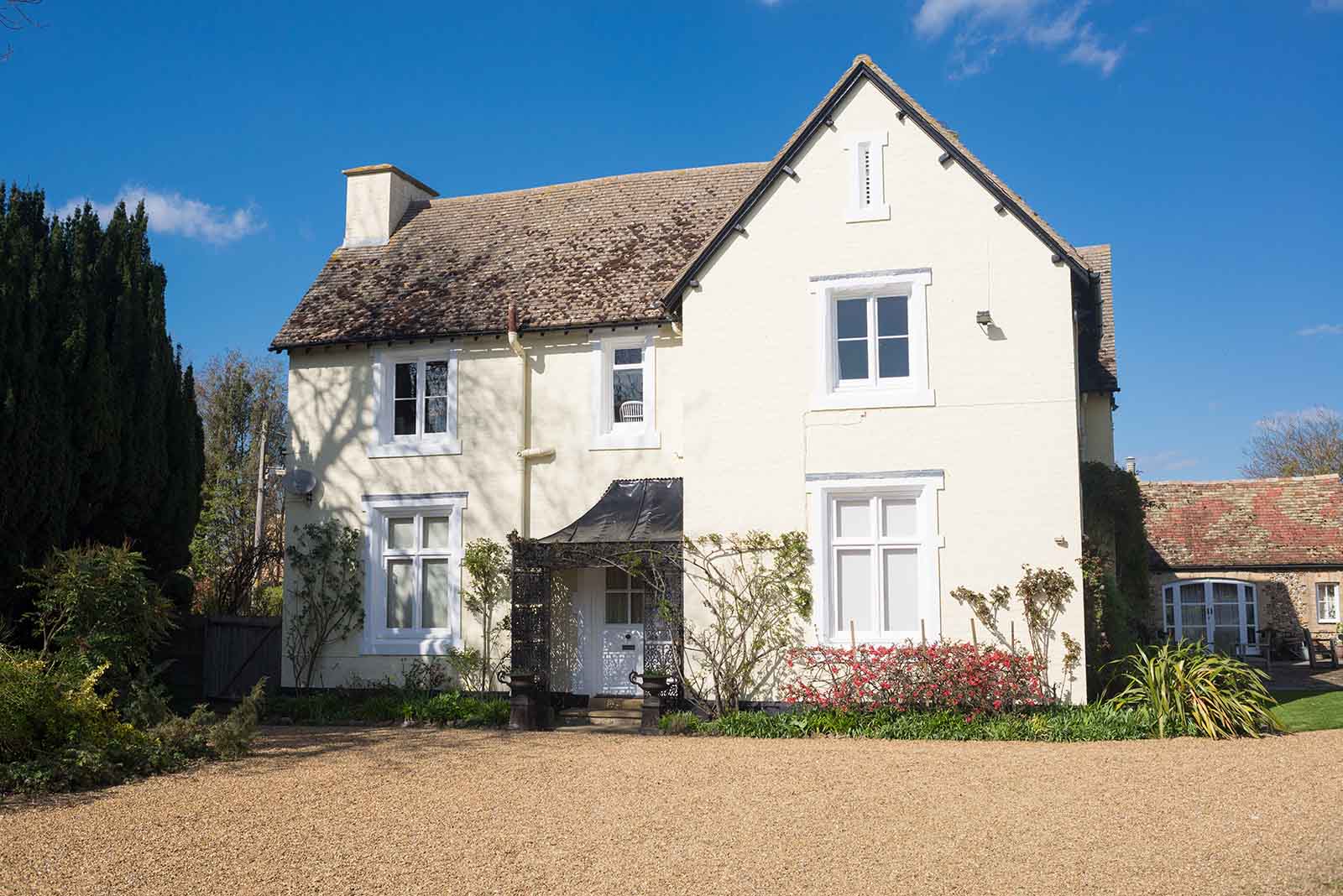 White traditional British country house with bigvgravel yard at