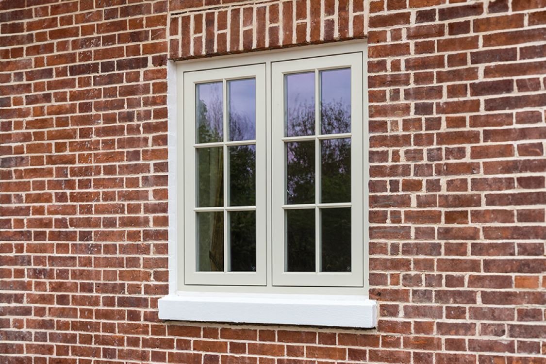oyster white timber casement window installed within red brick building