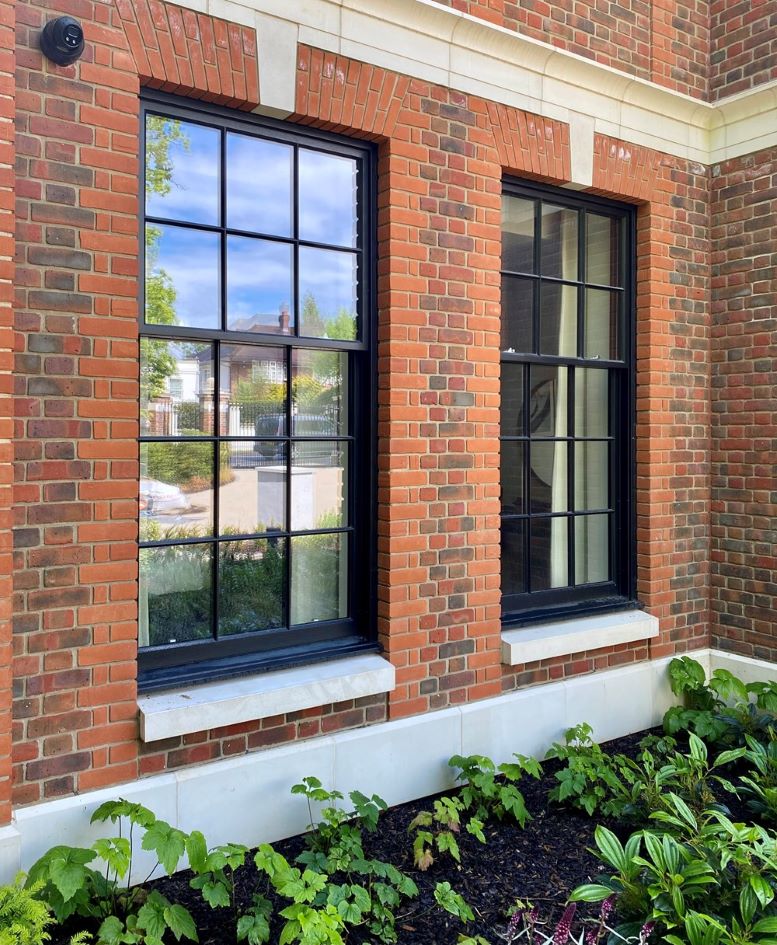 black Timber sash windows within red brick house