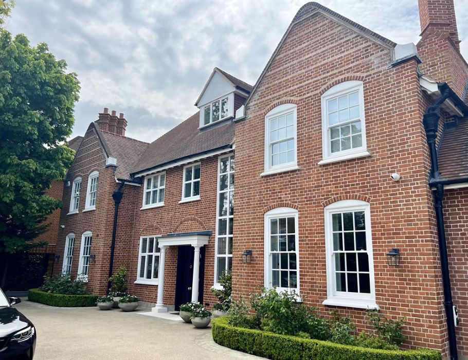 white timber double glazed sash windows installed, shown on front of large red brick property in North London