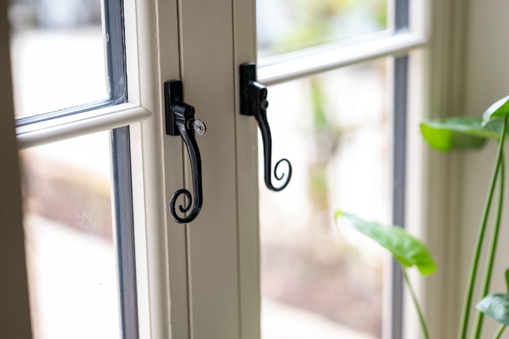 Close-up of a stylish cream Residence 7 window from Lomax + Wood, featuring black traditional hardware. Explore efficient, secure, & attractive windows.