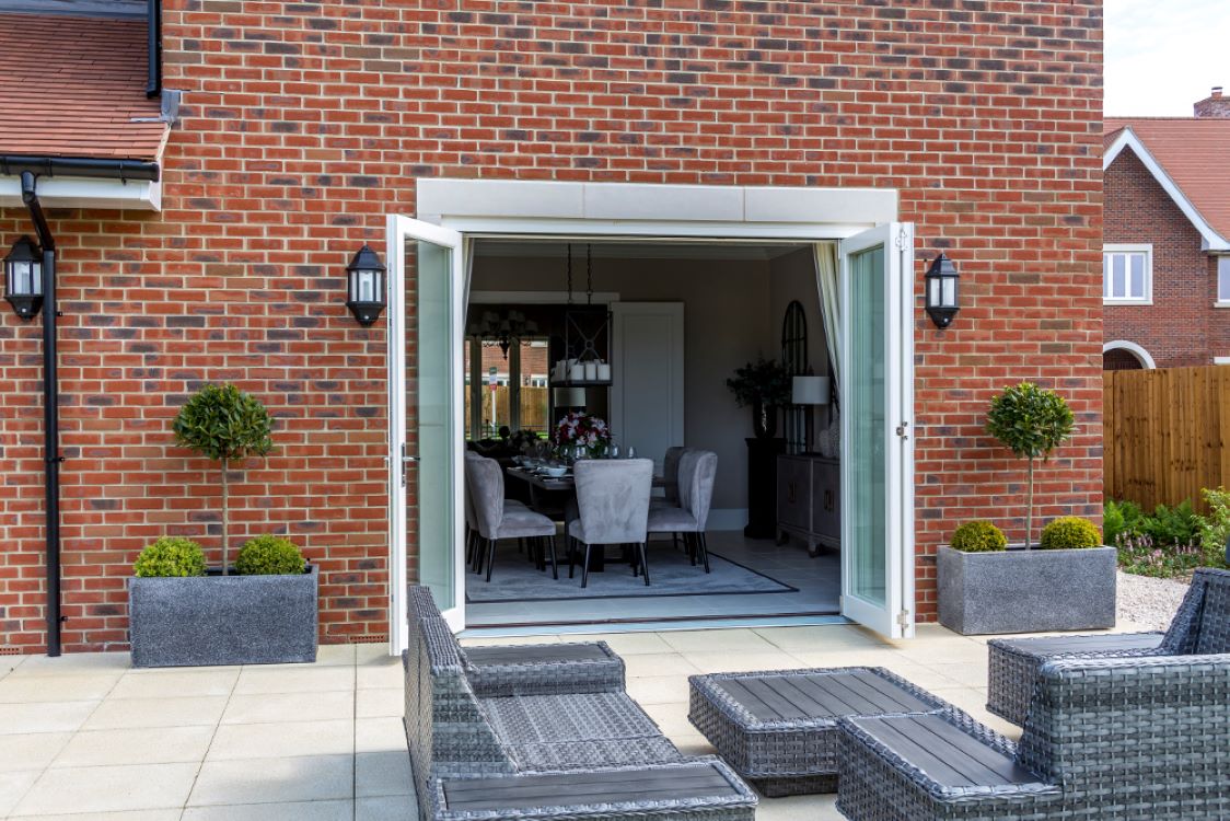 flush white timber bifold doors open on to a large patio